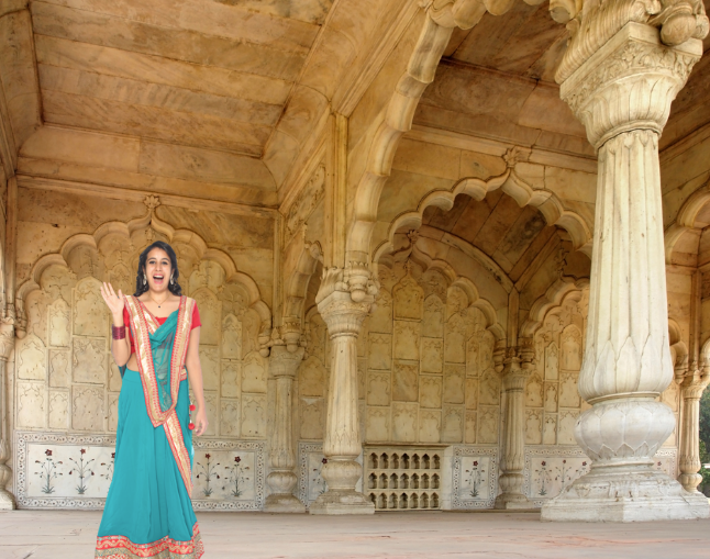 Indian woman in ethnic wear standing in front of elaborate arches and pillars