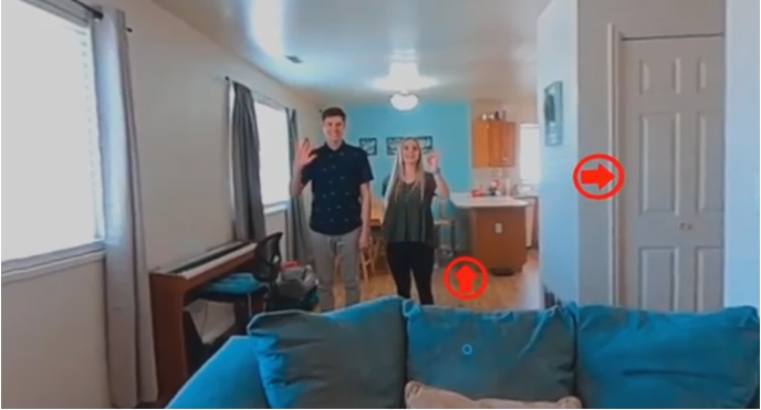 friendly couple waving hello inside their house