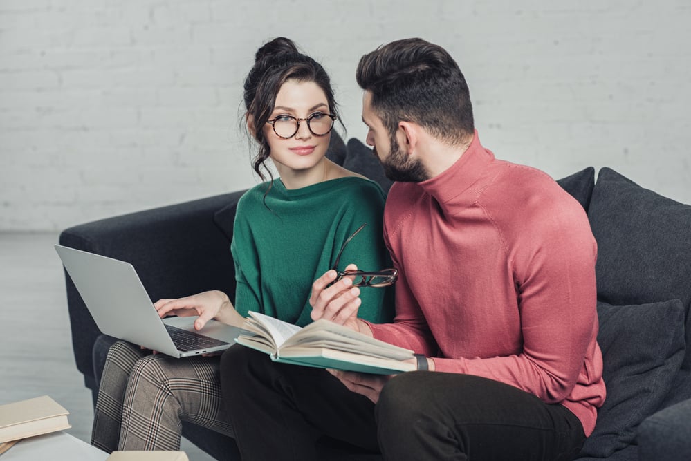 man-looking-at-cheerful-woman-in-glasses-sitting-w